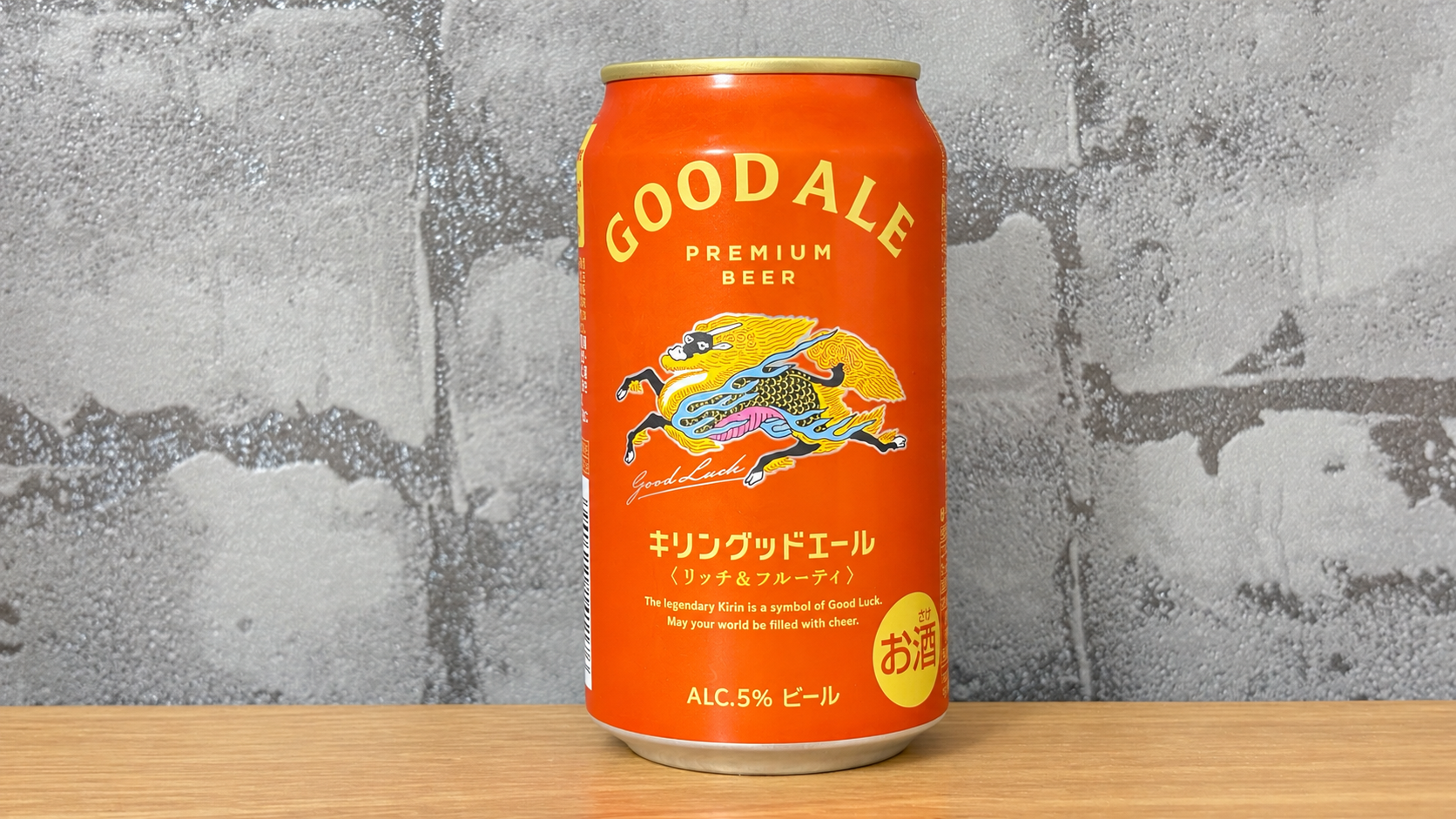 柄入りグレーの壁紙を背景に木の天板の中央に置いたキリングッドエールの缶
