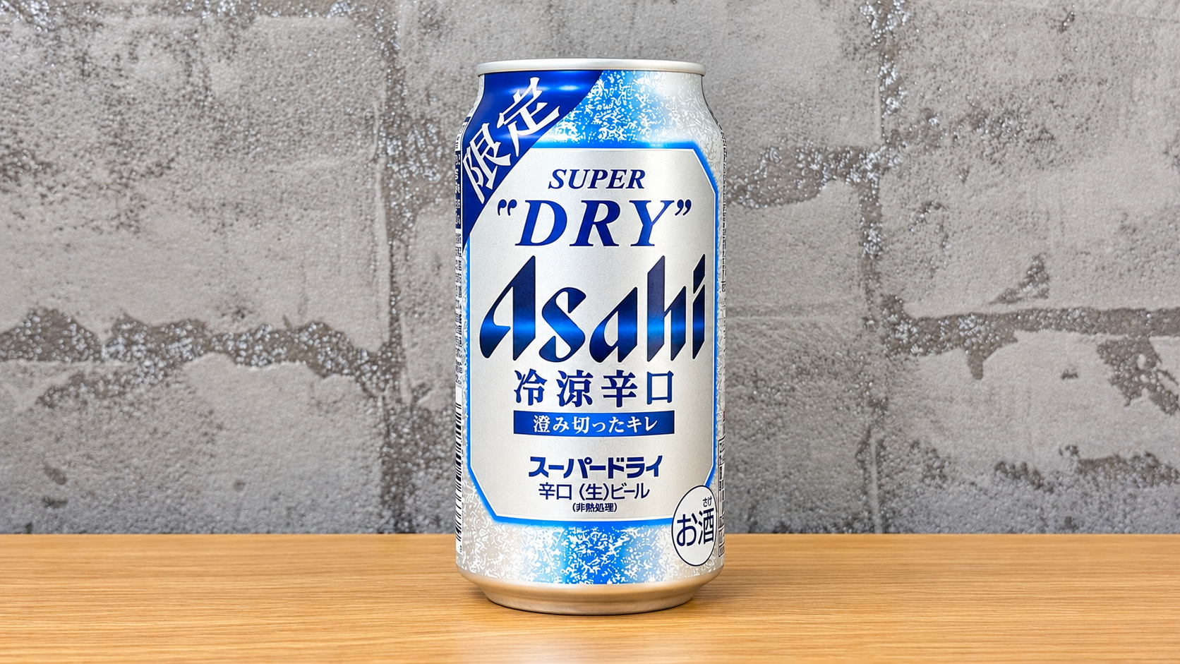 グレーの壁紙と木の天板を背景に中央に配置したアサヒスーパードライ冷涼辛口の缶